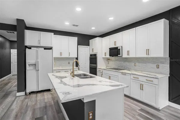 a kitchen with kitchen island granite countertop a sink appliances cabinets and counter space