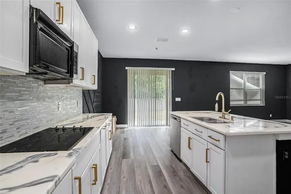 a kitchen that has a sink and a stove top oven