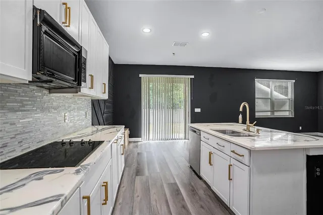a kitchen that has a sink and a stove top oven
