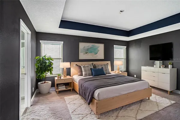 a spacious bedroom with a large bed and a flat screen tv
