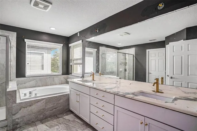 a bathroom with a granite countertop sink mirror and a bathtub