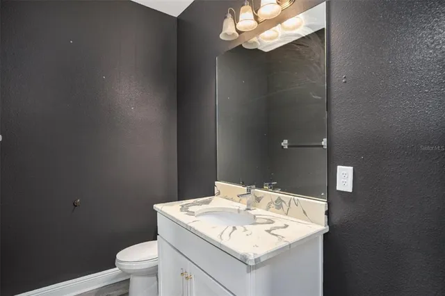 a bathroom with a sink a toilet and vanity