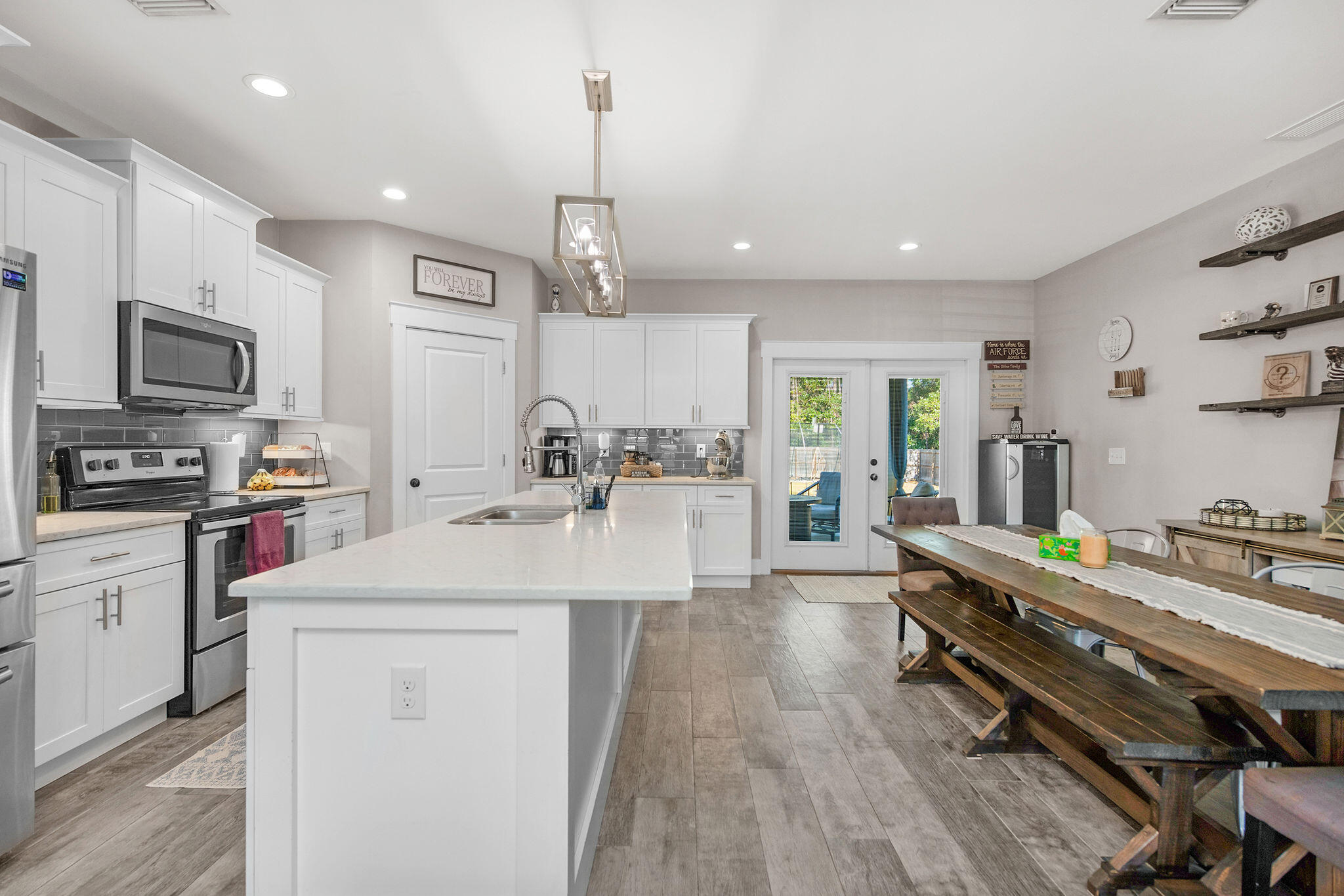8914 Timber Lane Navarre, FL 32566 - Photo 13 of 40 a kitchen with stainless steel appliances a sink a stove a refrigerator cabinets and living room view