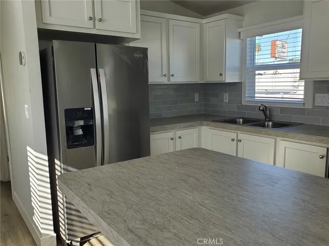 a kitchen with granite countertop a refrigerator and a sink