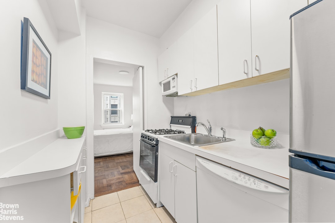 11 Riverside Drive, Unit 15OE Manhattan, NY 10023 - Photo 5 of 12 a kitchen with a sink a stove cabinets and wooden floor