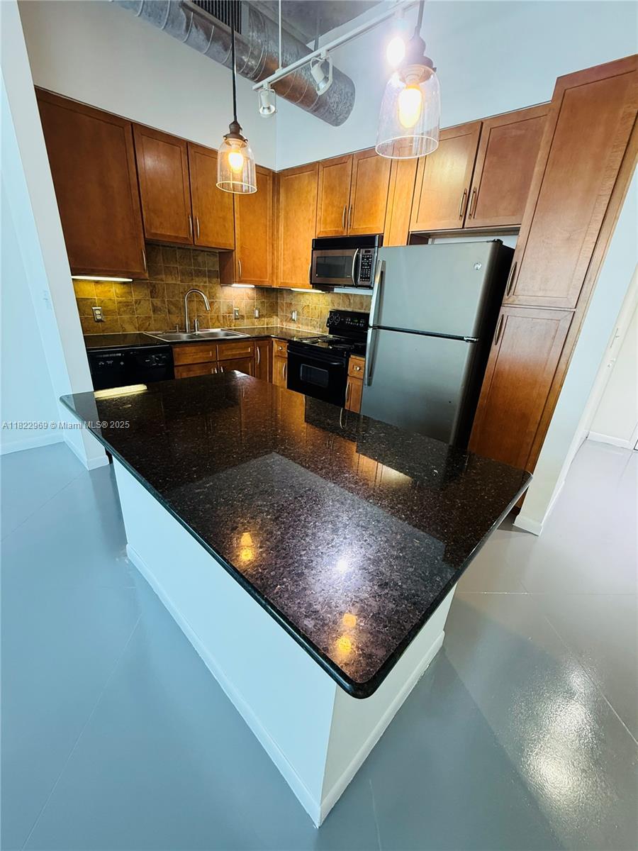 2001 Biscayne Boulevard, Unit 2402 Miami, FL 33137 - Photo 15 of 64 a kitchen with stainless steel appliances granite countertop a sink refrigerator and microwave
