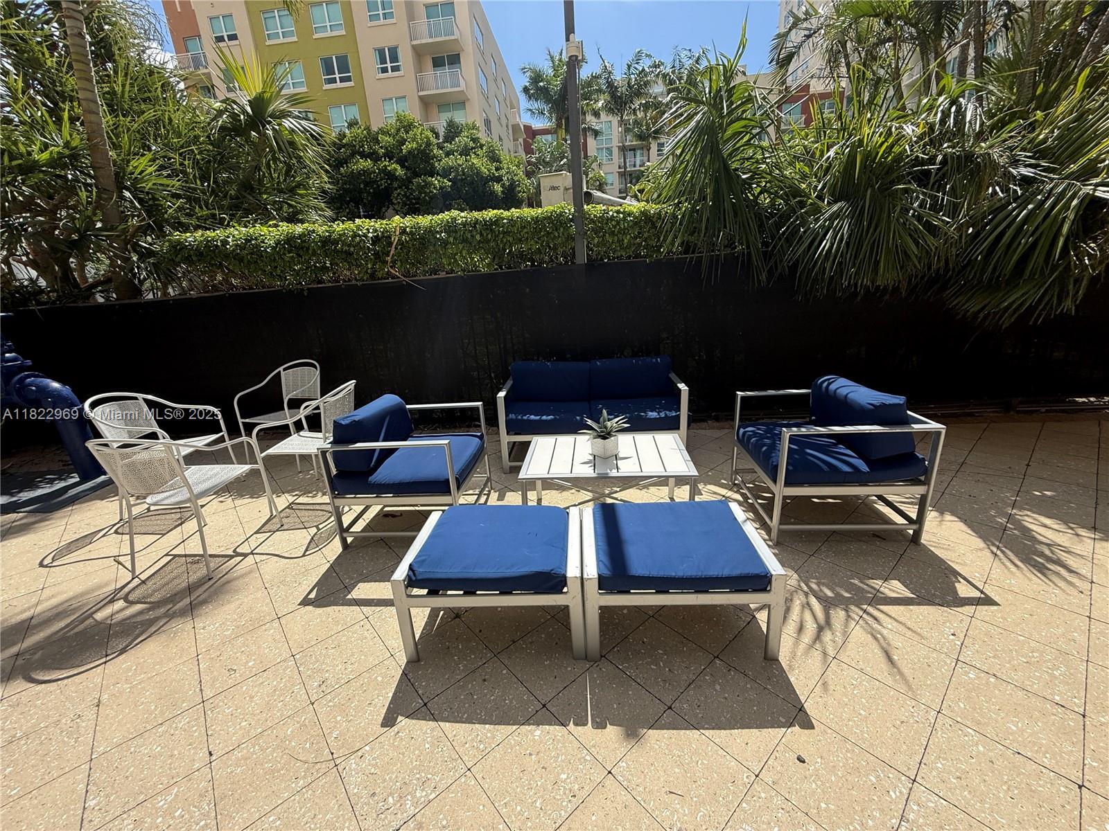 2001 Biscayne Boulevard, Unit 2402 Miami, FL 33137 - Photo 41 of 64 a view of a patio with table and chairs with wooden floor and fence