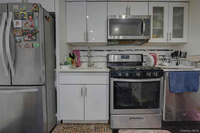a kitchen with stainless steel appliances granite countertop a refrigerator stove and sink