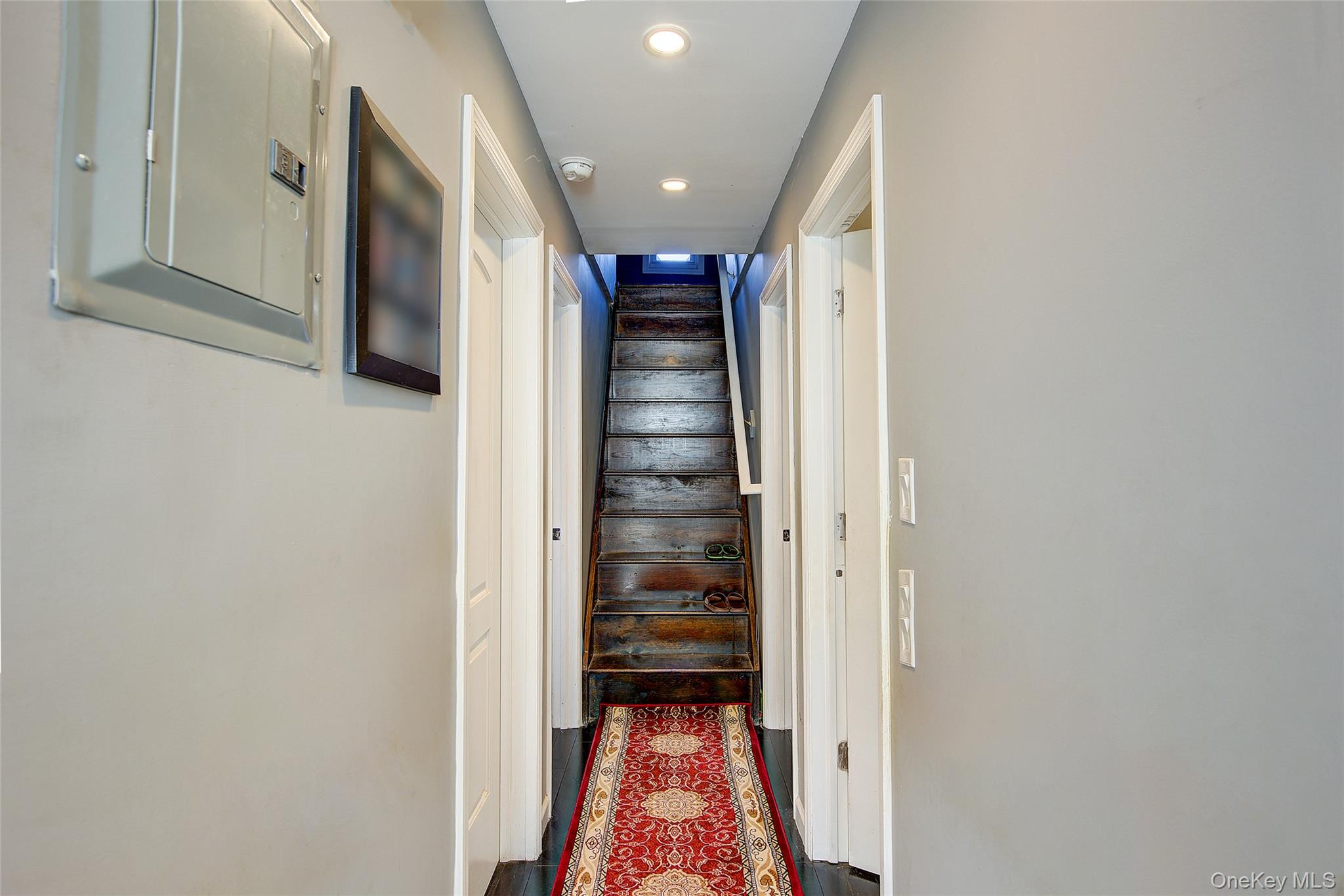 89-06 175th Street Queens, NY 11432 - Photo 12 of 29 Hallway featuring electric panel, recessed lighting, stairs, and dark wood-style flooring