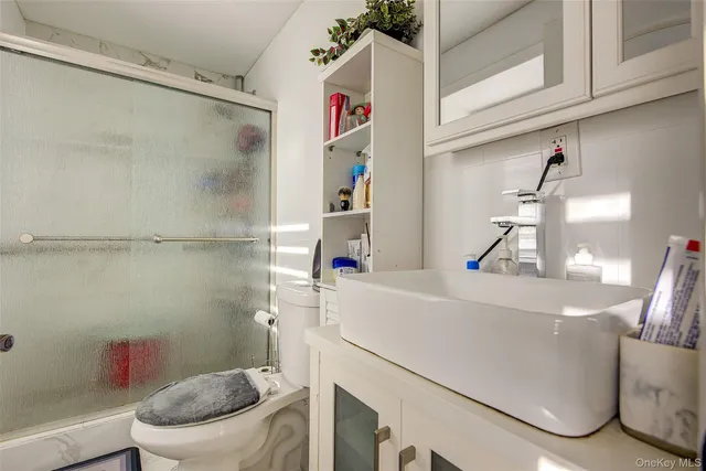 a bathroom with a sink a toilet and a shower curtain
