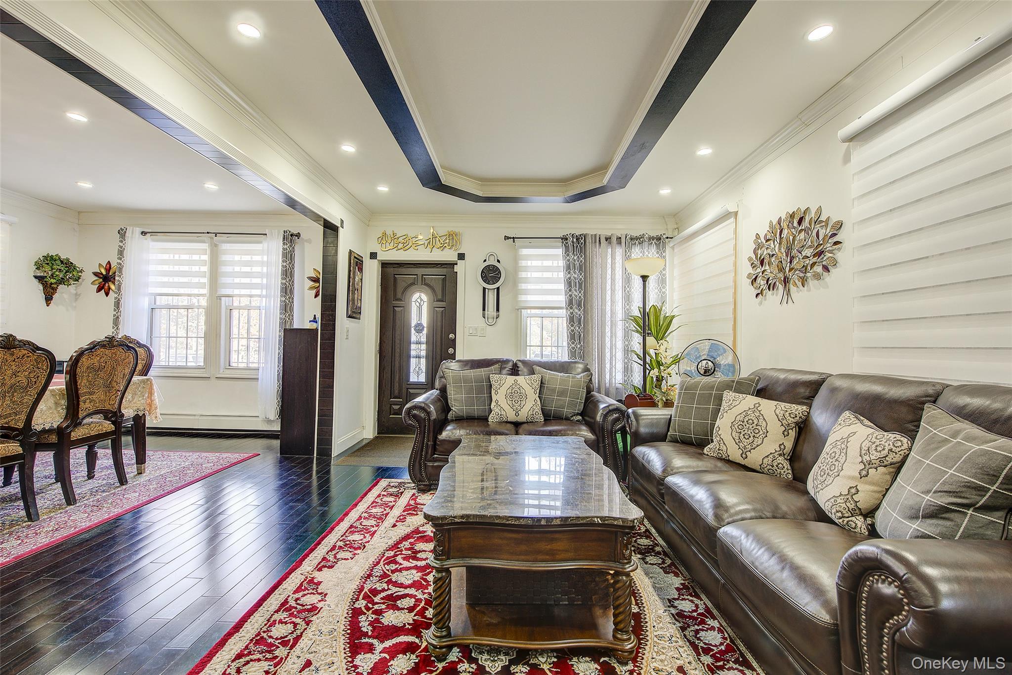 89-06 175th Street Queens, NY 11432 - Photo 3 of 29 Living area with crown molding, dark wood-style flooring, a tray ceiling, and recessed lighting