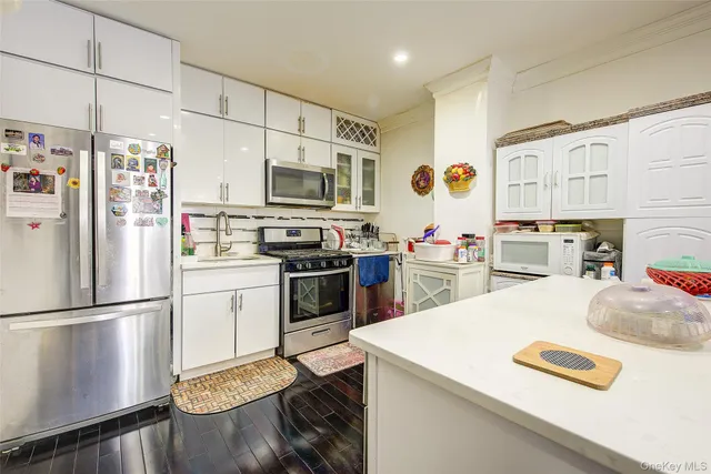 a kitchen with stainless steel appliances a stove refrigerator sink and a refrigerator