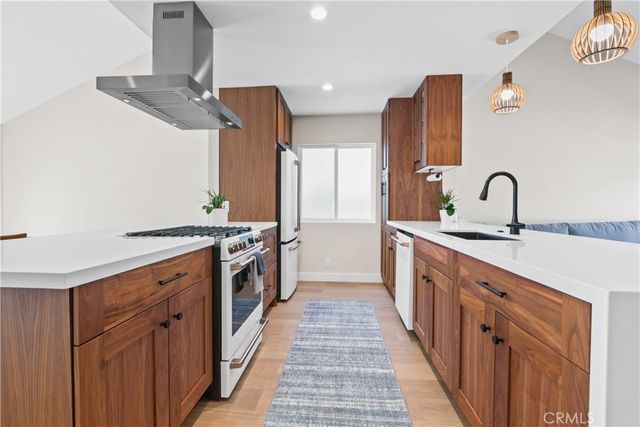a kitchen with stainless steel appliances a sink and a refrigerator