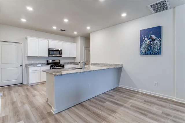 a kitchen with stainless steel appliances a refrigerator and a stove top oven