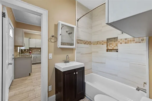 a living room with furniture and a flat screen tv with kitchen view
