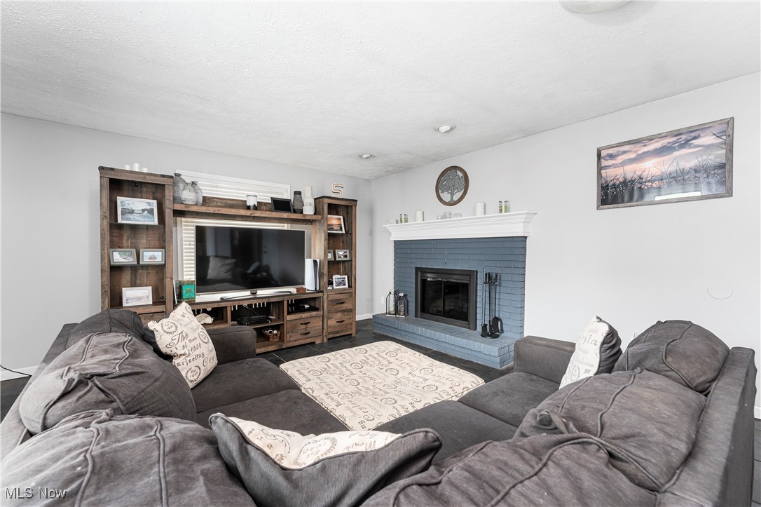 6254 Stanbury Road Parma, OH 44129 - Photo 20 of 44 Living room with a fireplace and a textured ceiling