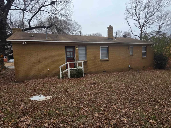a backyard of a house with table and chairs