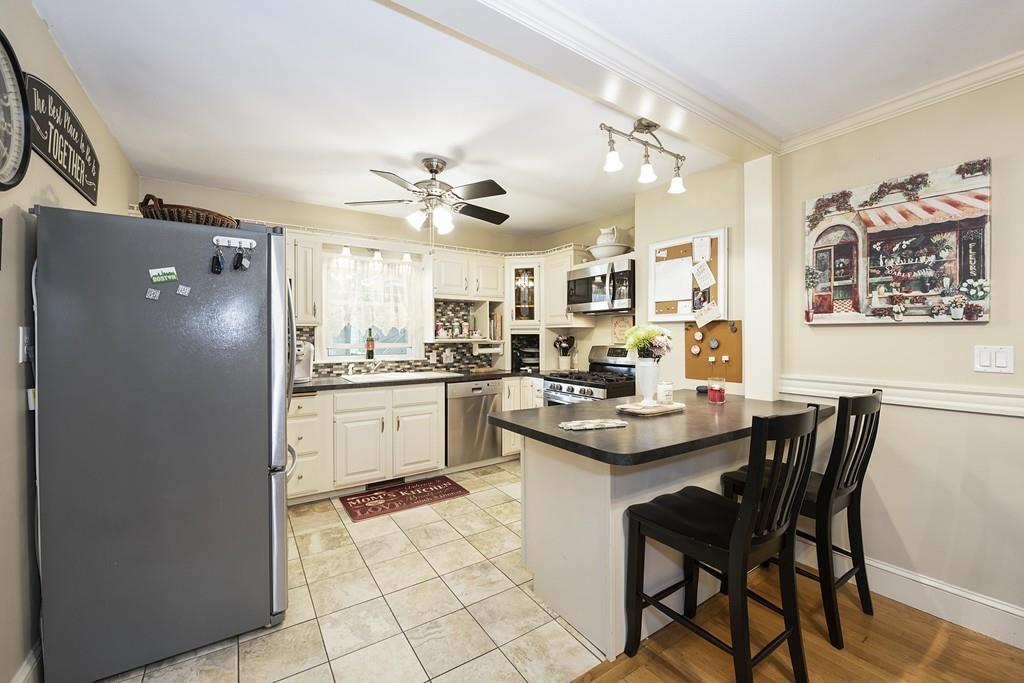 26 Elsworth Road Newton, MA 02465 - Photo 6 of 18 a kitchen with a dining table chairs cabinets and stainless steel appliances