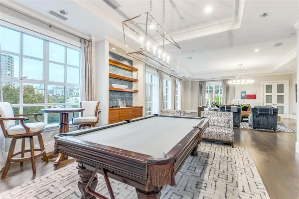 a living room with furniture a table and large windows