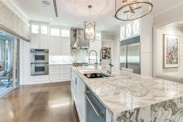 a kitchen with kitchen island granite countertop a sink cabinets and stainless steel appliances