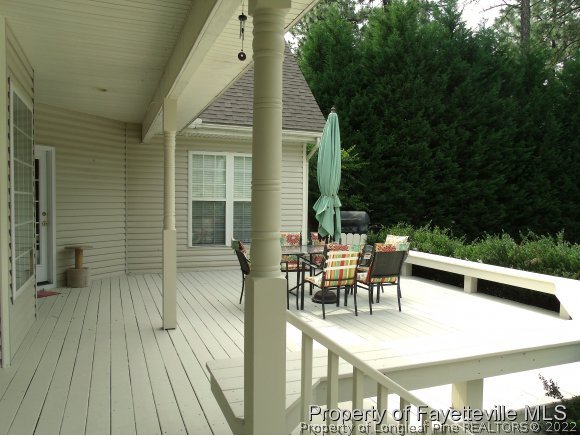702 Wildwood Road Aberdeen, NC 28315 - Photo 16 of 19 a view of a patio with table and chairs with wooden floor and fence