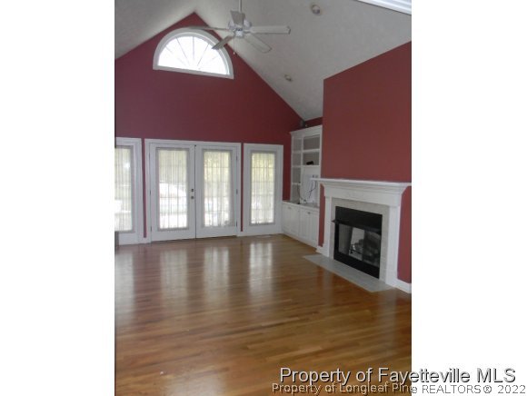 702 Wildwood Road Aberdeen, NC 28315 - Photo 7 of 19 a view of an empty room with wooden floor and a fireplace