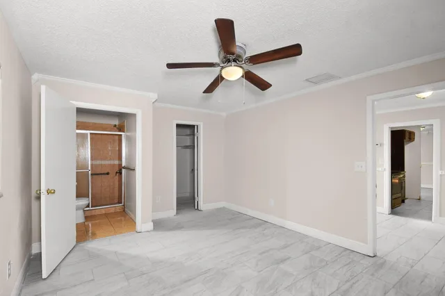 an empty room with closet and a ceiling fan
