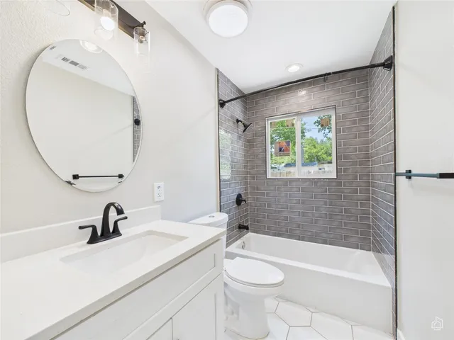 a bathroom with a sink a toilet and a mirror