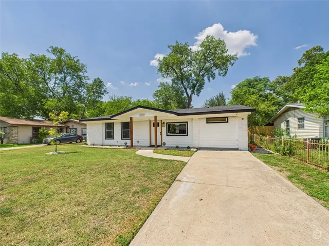 a front view of a house with a yard and trees