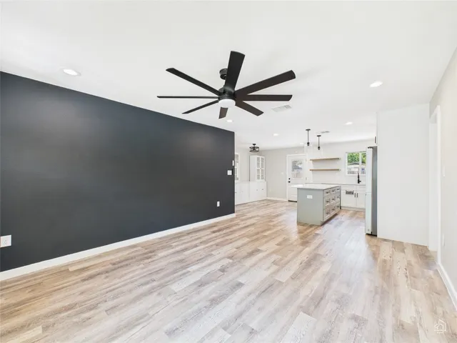 a view of empty room with wooden floor and a ceiling fan