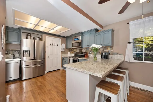 a kitchen with granite countertop a refrigerator and a stove top oven