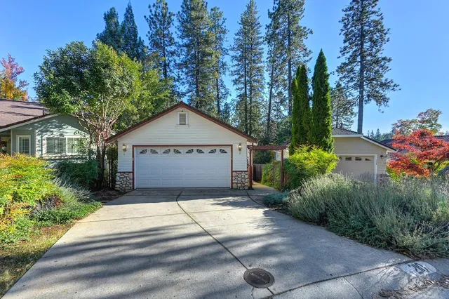 a front view of a house with a yard and trees