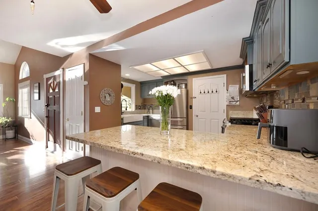 a kitchen with stainless steel appliances a sink cabinets and a window