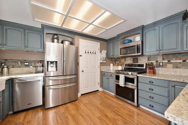 a spacious bathroom with a granite countertop sink a mirror and a shower