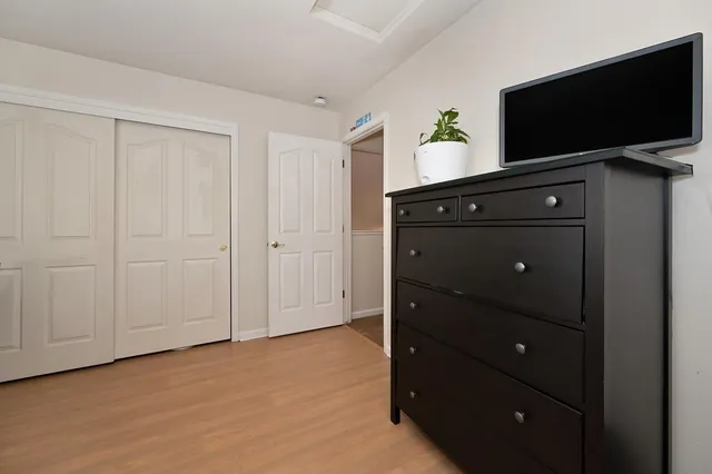a bedroom with a bed and wooden floor