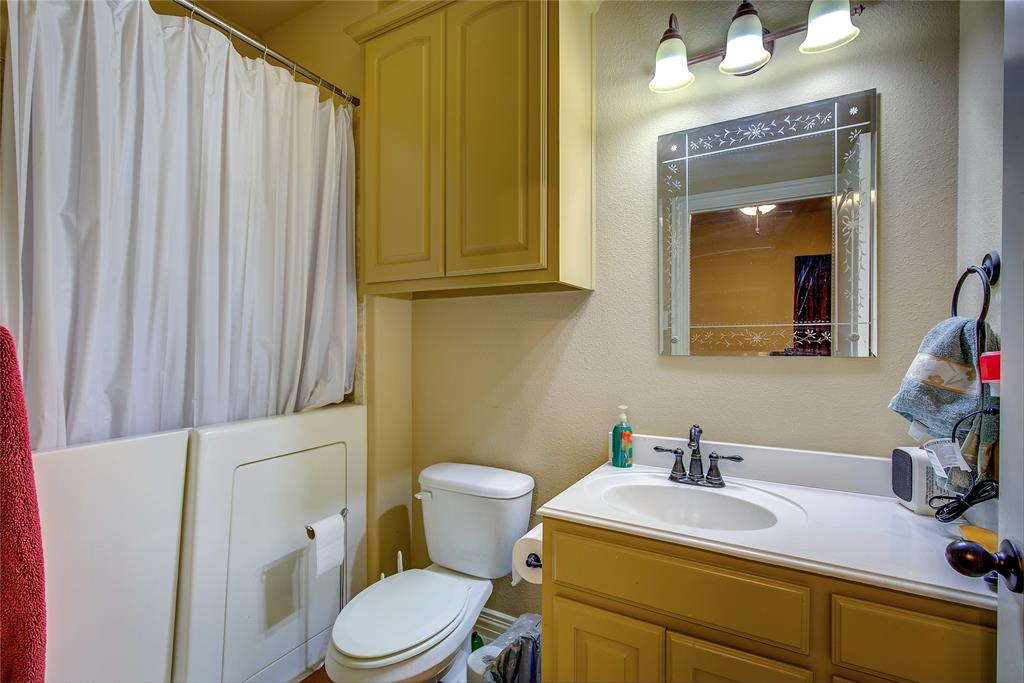 1066 Canyon Lake Road Wills Point, TX 75169 - Photo 18 of 40 a bathroom with a sink vanity mirror and toilet