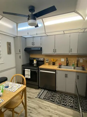 a kitchen with a sink a stove and white cabinets