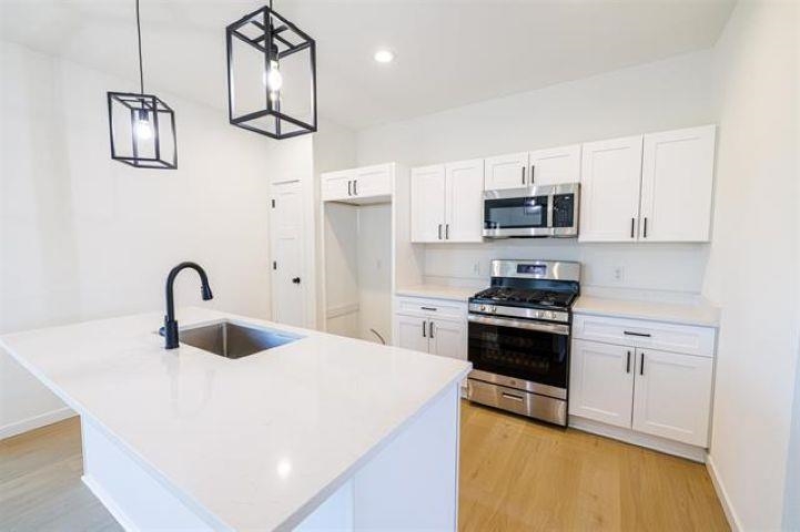 14192 Prairie Commons Lane South Beloit, IL 61080 - Photo 10 of 29 a kitchen with kitchen island a sink and a stove top oven