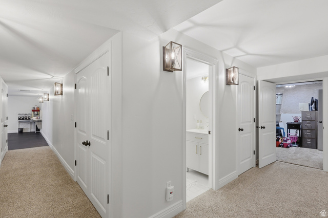 10676 Urban Rdg Cove South Jordan, UT 84095 - Photo 37 of 48 Hallway featuring neutral carpet flooring, crisp white walls, and contemporary wall sconces