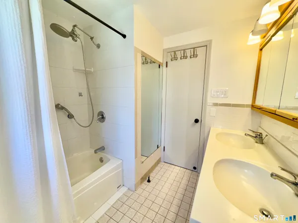 a bathroom with a tub sink and mirror