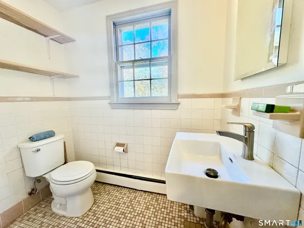 a bathroom with a sink a toilet and a window