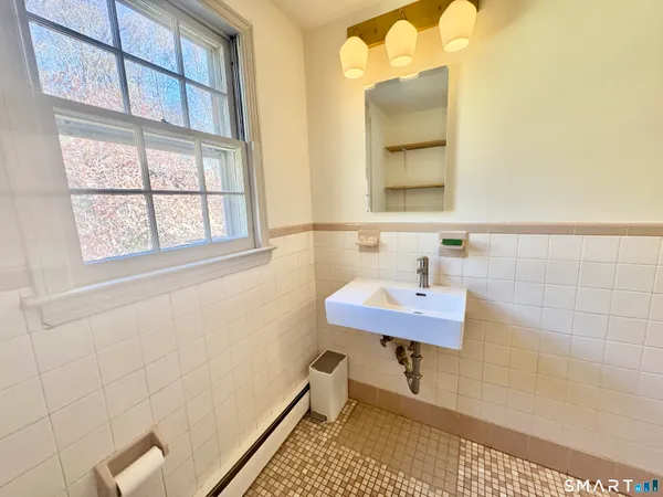 a bathroom with a sink a toilet and a window