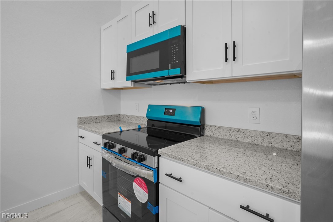 634 Knapp Street Lehigh Acres, FL 33974 - Photo 14 of 29 a kitchen with stainless steel appliances granite countertop a sink and a microwave