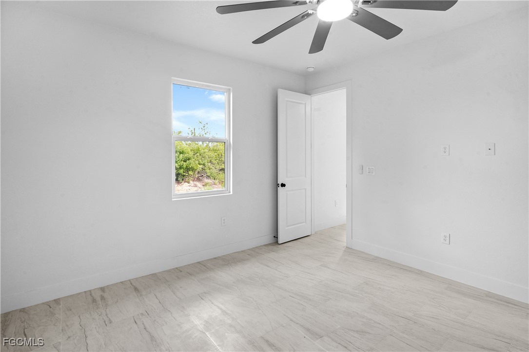 634 Knapp Street Lehigh Acres, FL 33974 - Photo 21 of 29 an empty room with windows and fan