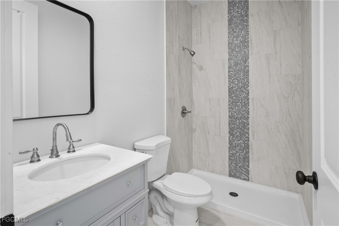 634 Knapp Street Lehigh Acres, FL 33974 - Photo 25 of 29 a bathroom with a sink toilet and shower