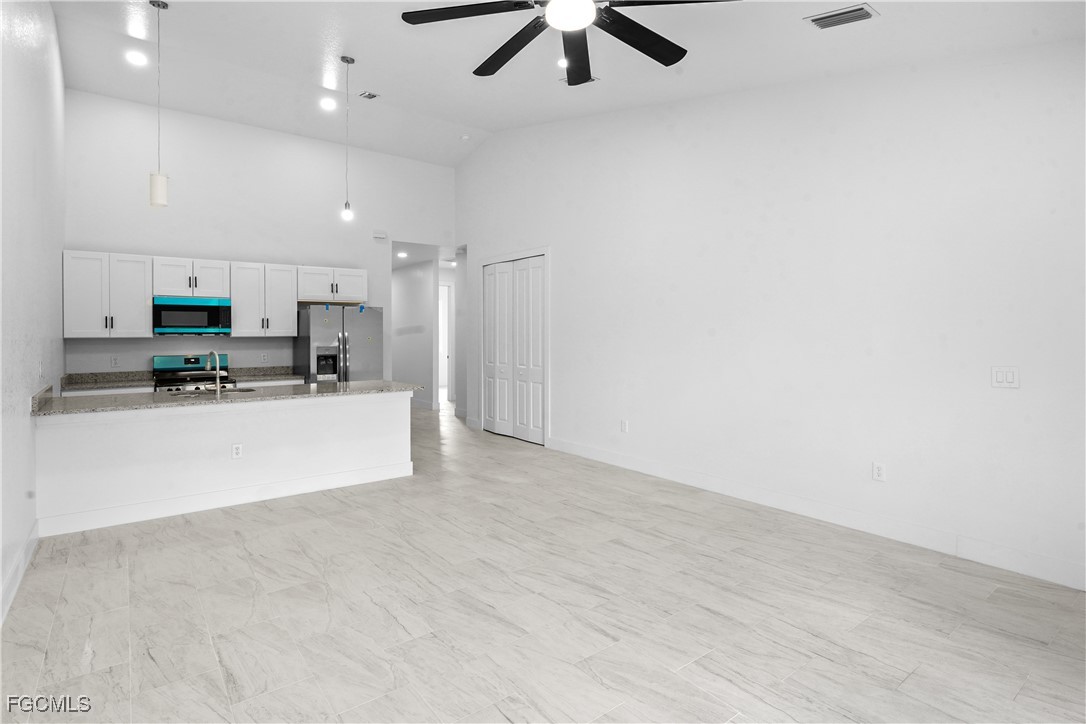 634 Knapp Street Lehigh Acres, FL 33974 - Photo 3 of 29 a view of kitchen with stainless steel appliances refrigerator oven and white cabinets