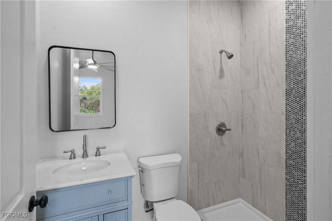 634 Knapp Street Lehigh Acres, FL 33974 - Photo 8 of 29 a bathroom with a toilet a sink and mirror