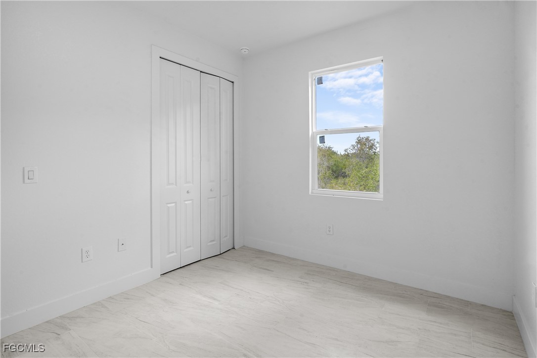634 Knapp Street Lehigh Acres, FL 33974 - Photo 9 of 29 an empty room with windows