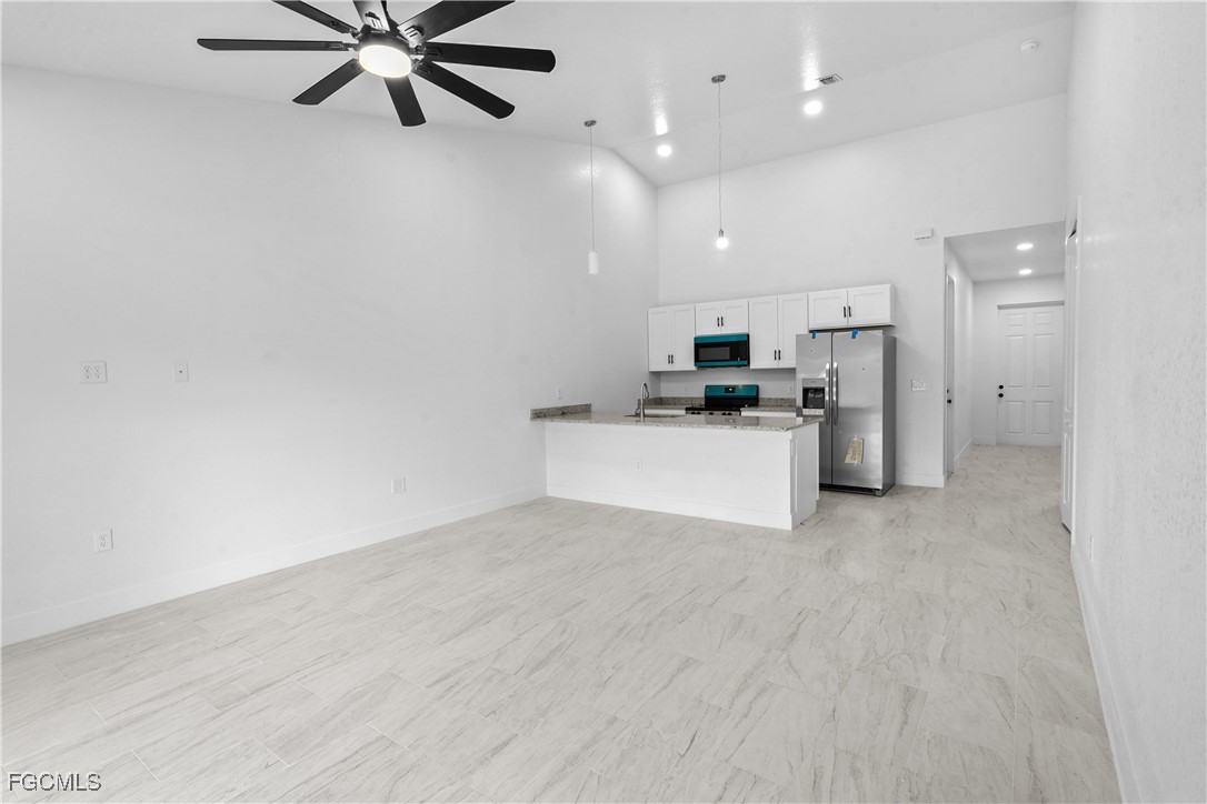 634 Knapp Street Lehigh Acres, FL 33974 - Photo 10 of 29 a view of a kitchen with a sink and a refrigerator