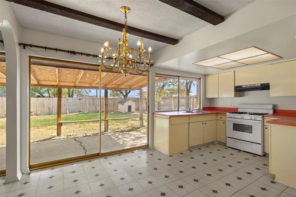 1400 Ridgecrest Drive Plano, TX 75074 - Photo 8 of 32 a kitchen with a stove a sink and a refrigerator